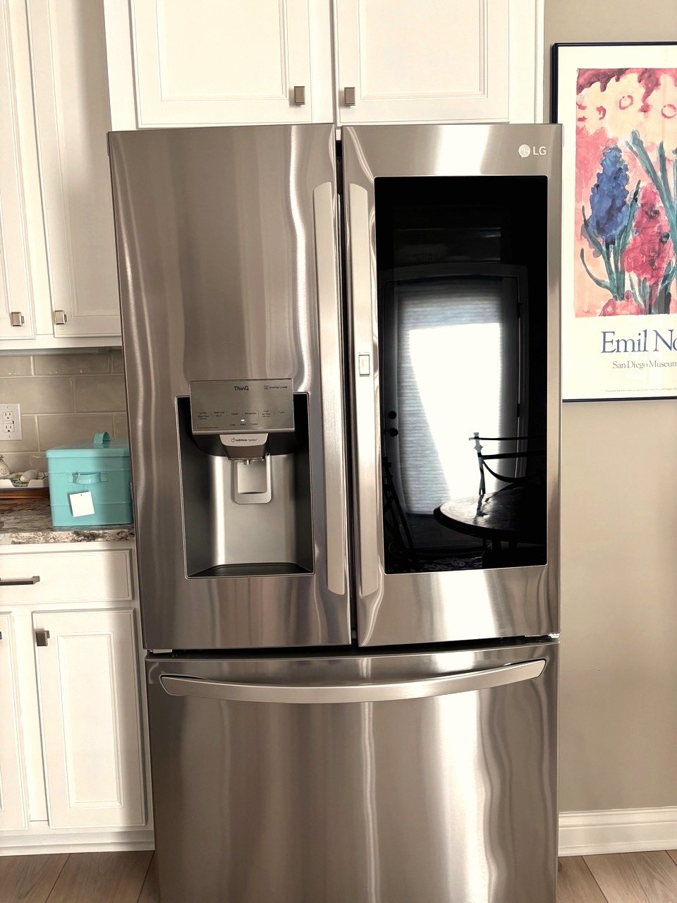 A cleaned stainless steel refrigerator in a white kitchen